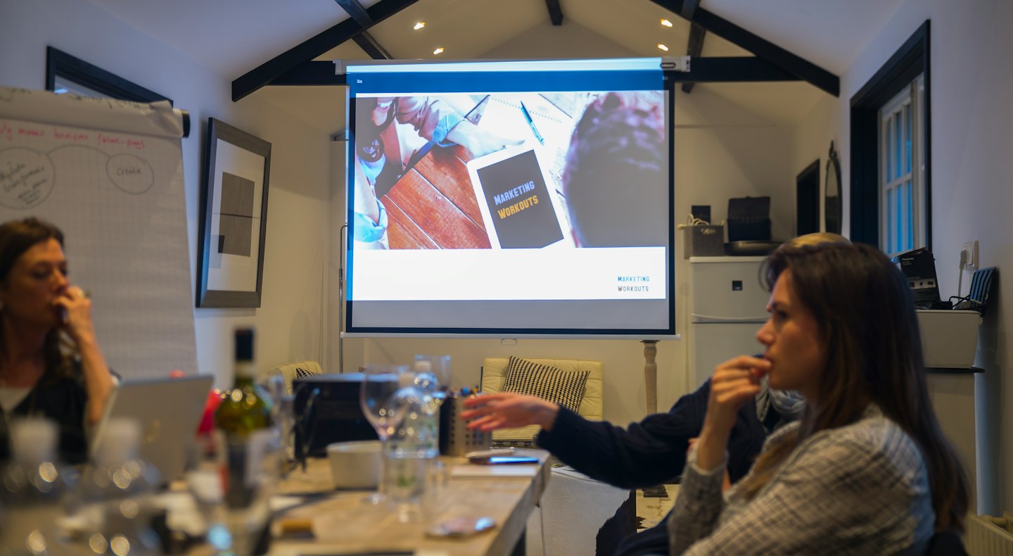 Professionisti aziendali partecipano a un workshop di marketing in una sala riunioni.